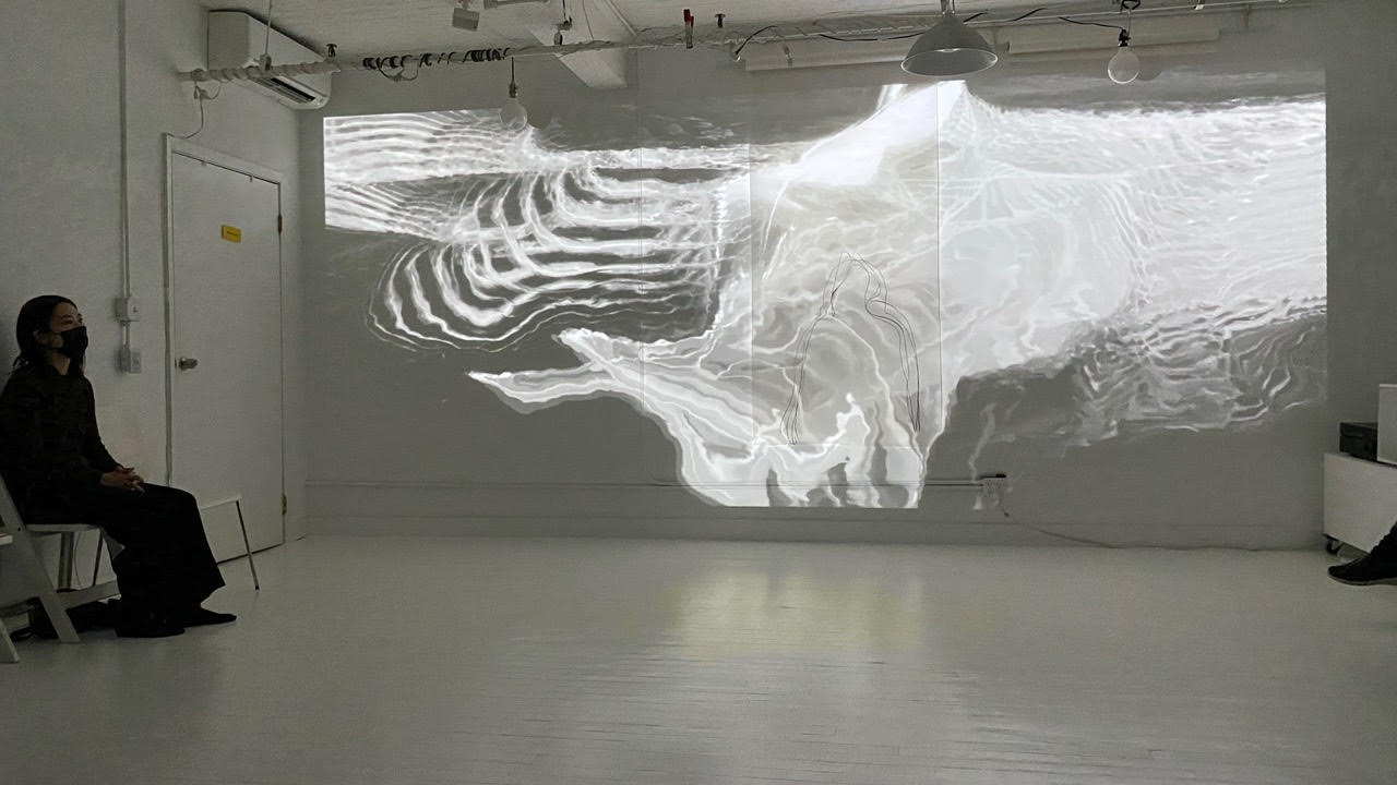 a ghostly white projection on the wall of a totally white room, it could be an abstraction of the sea or sound waves